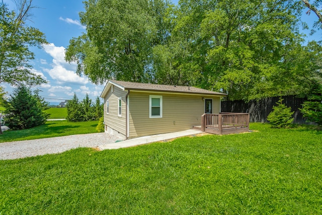 back of property with a yard and a deck