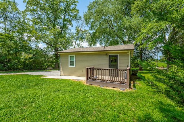 rear view of property featuring a lawn and a deck