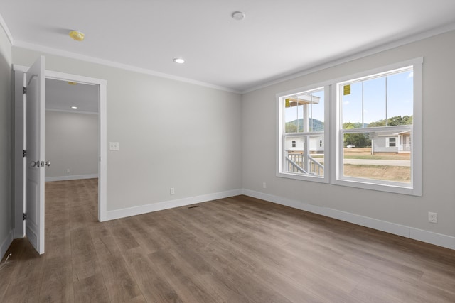 spare room with crown molding and hardwood / wood-style floors