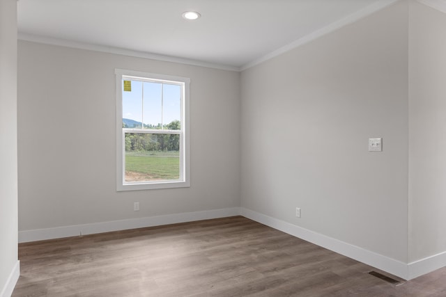 empty room with crown molding and hardwood / wood-style flooring