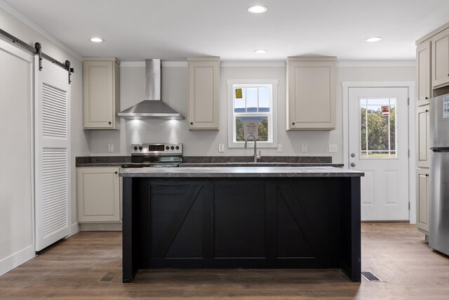 kitchen with hardwood / wood-style floors, sink, wall chimney range hood, a barn door, and electric range