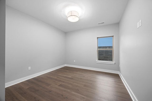 unfurnished room with dark wood-type flooring