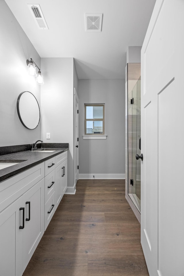 bathroom featuring vanity, hardwood / wood-style flooring, and a shower with door