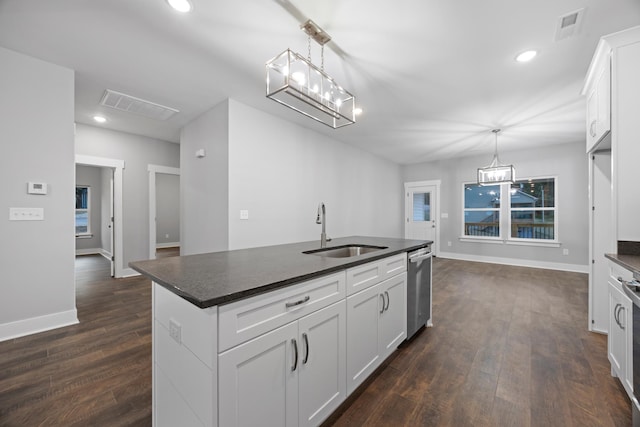 kitchen with white cabinetry, hanging light fixtures, sink, and an island with sink