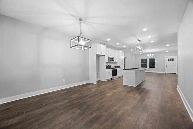 kitchen with stainless steel appliances, white cabinetry, dark hardwood / wood-style flooring, pendant lighting, and a center island