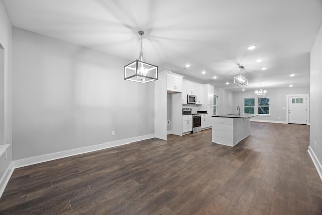 kitchen with stainless steel appliances, white cabinetry, sink, decorative light fixtures, and dark hardwood / wood-style flooring