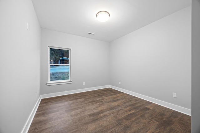 spare room featuring dark wood-type flooring