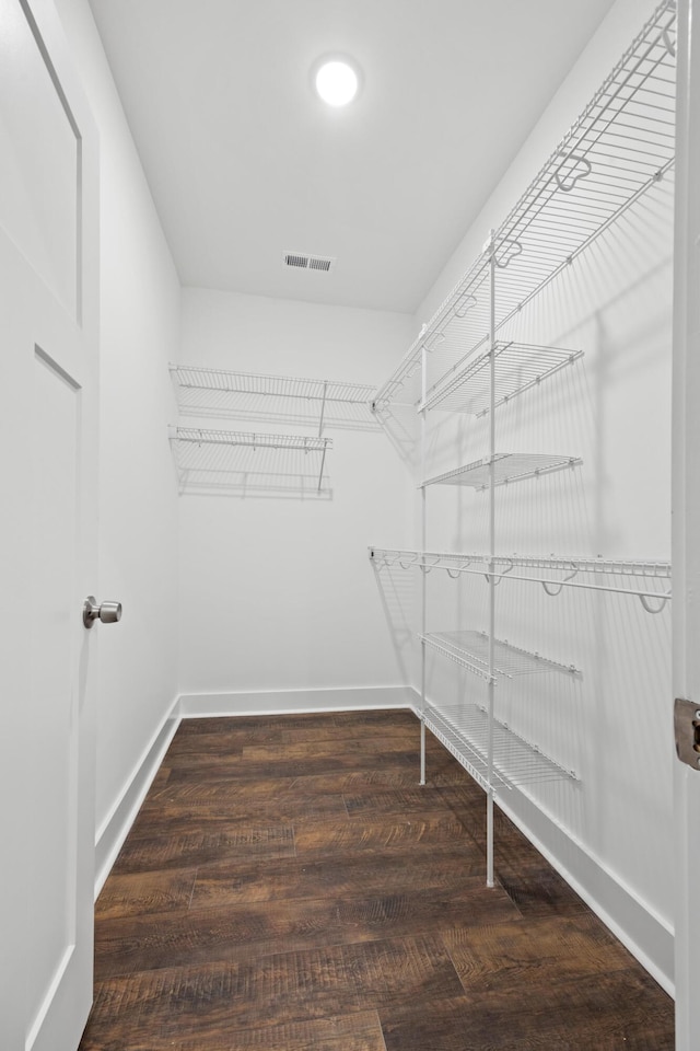 spacious closet with dark hardwood / wood-style floors