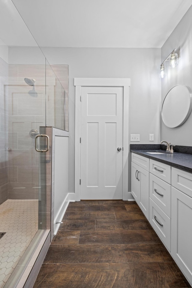 bathroom featuring hardwood / wood-style floors, an enclosed shower, and vanity