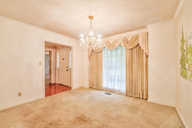 carpeted empty room featuring crown molding, a textured ceiling, and a chandelier