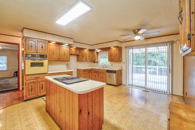 kitchen featuring a kitchen island, white oven, electric cooktop, stainless steel dishwasher, and ceiling fan