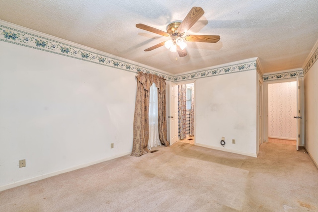 spare room with ceiling fan, light colored carpet, and a textured ceiling