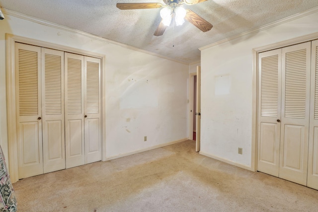 unfurnished bedroom featuring a textured ceiling, light colored carpet, ceiling fan, and ornamental molding