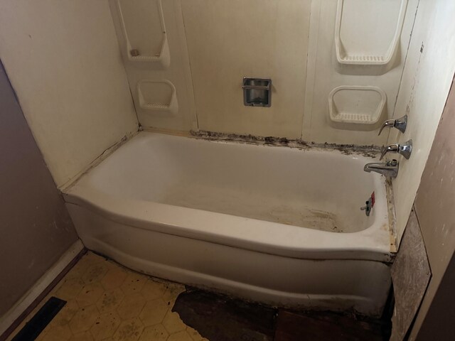 bathroom with tile patterned floors and a bathtub