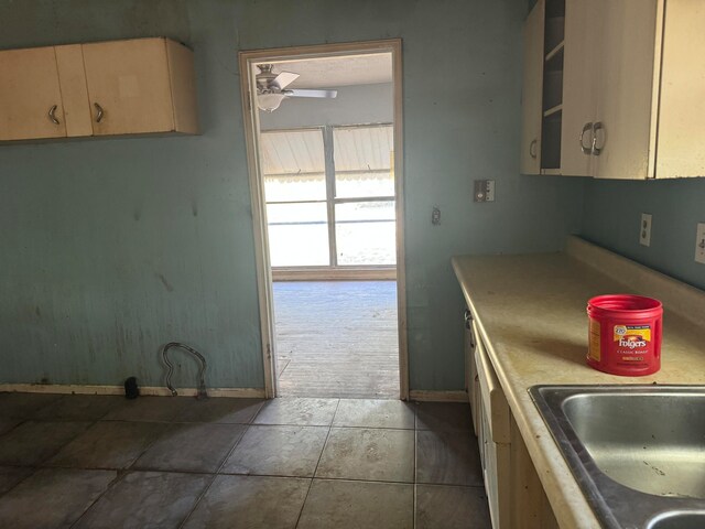 kitchen featuring ceiling fan, light brown cabinets, dark tile patterned floors, and sink