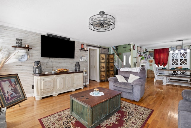 living room featuring hardwood / wood-style flooring, wood walls, and a barn door