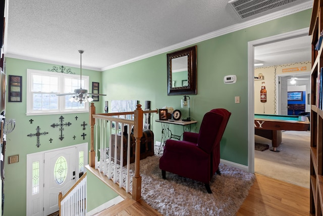 sitting room with a textured ceiling, billiards, ornamental molding, ceiling fan, and light wood-type flooring