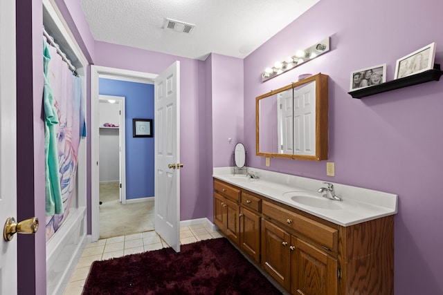 bathroom with tile patterned flooring, shower / tub combo with curtain, a textured ceiling, and vanity