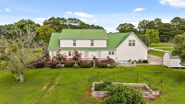 back of house featuring a wooden deck, a lawn, and a shed