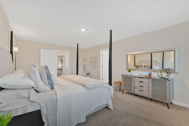 bedroom featuring light carpet and connected bathroom