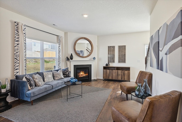 living room with dark wood-type flooring and a textured ceiling