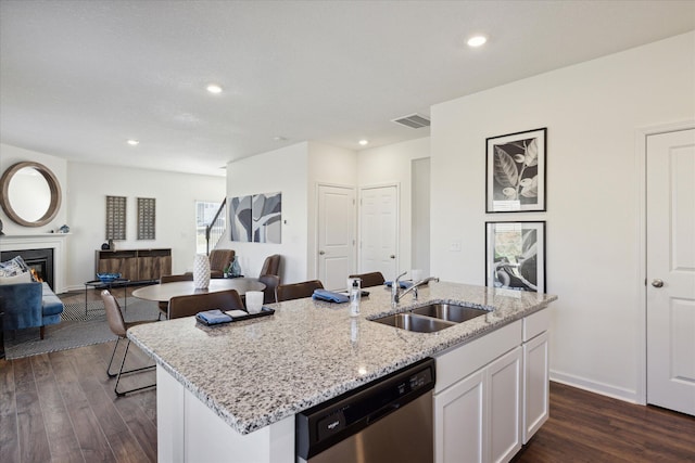 kitchen with white cabinetry, sink, dark hardwood / wood-style floors, a center island with sink, and stainless steel dishwasher