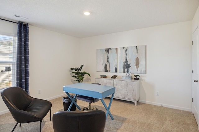 carpeted home office featuring a textured ceiling