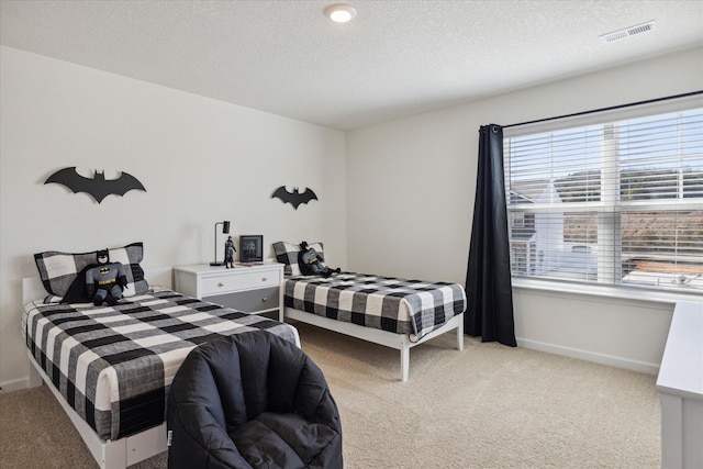 bedroom featuring light colored carpet and a textured ceiling