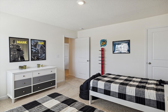 bedroom featuring light carpet and a textured ceiling