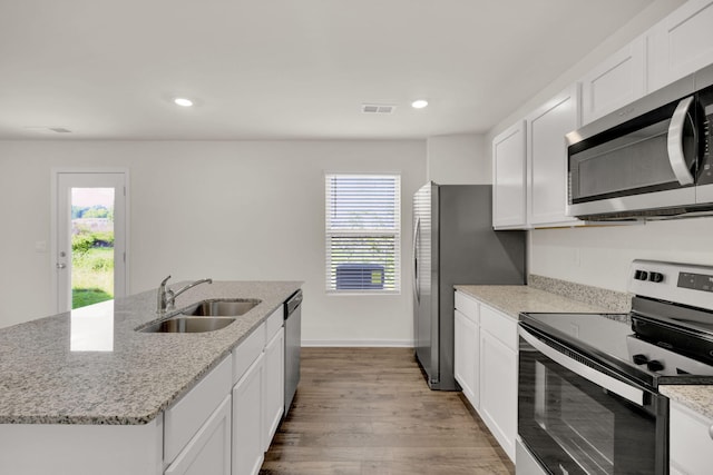 kitchen featuring visible vents, light wood-style flooring, a sink, appliances with stainless steel finishes, and white cabinetry