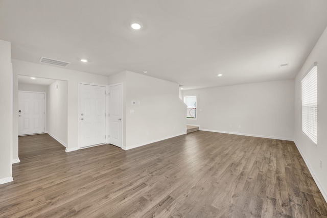 unfurnished room with recessed lighting, wood finished floors, visible vents, and baseboards