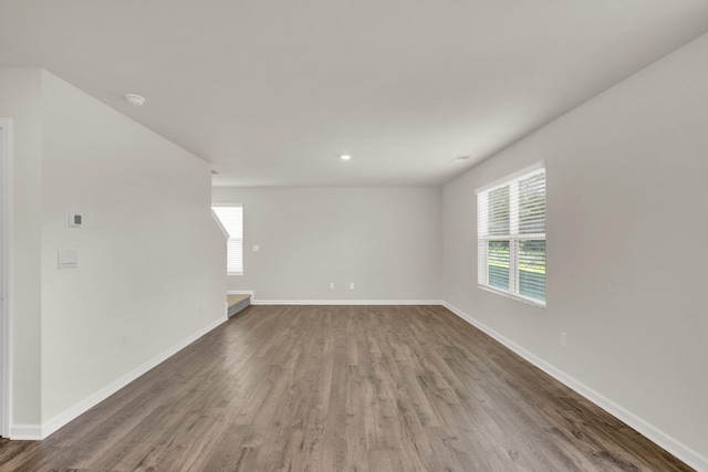 spare room with wood finished floors, baseboards, and a wealth of natural light