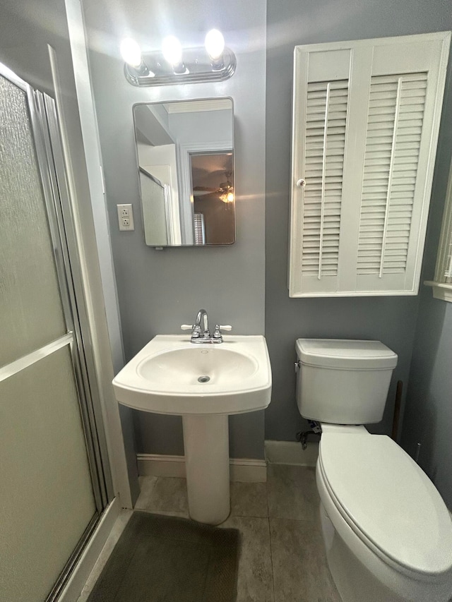 bathroom featuring toilet, tile patterned floors, and walk in shower