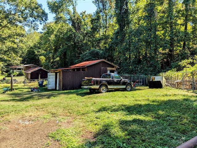 view of yard featuring a garage and an outbuilding