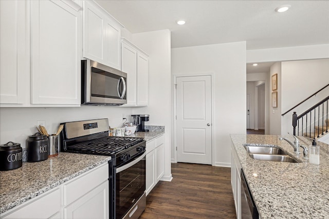 kitchen with white cabinetry, stainless steel appliances, sink, light stone countertops, and dark hardwood / wood-style floors