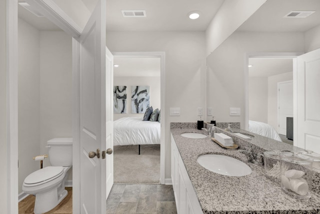 ensuite bathroom featuring a sink, connected bathroom, and visible vents