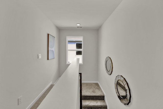 stairway with visible vents, carpet flooring, and baseboards