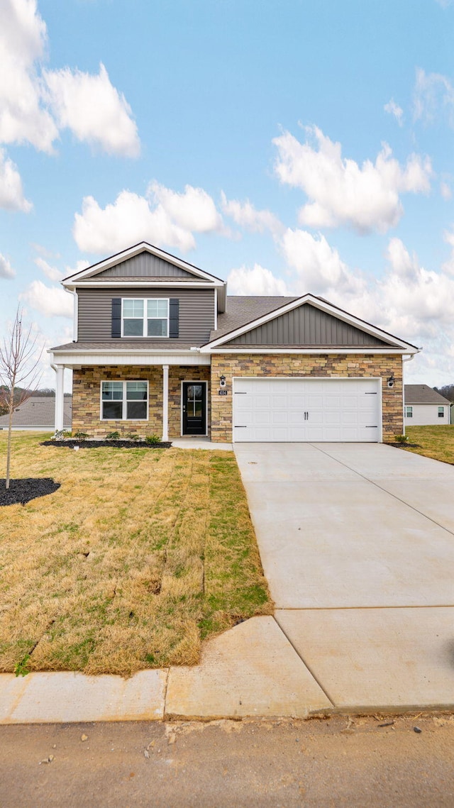 view of front of house with board and batten siding, concrete driveway, a front yard, a garage, and stone siding