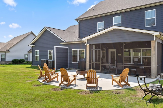 back of property with a fire pit, central AC, a patio, a yard, and a sunroom