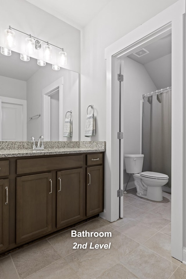 bathroom with vanity, toilet, walk in shower, and tile patterned flooring