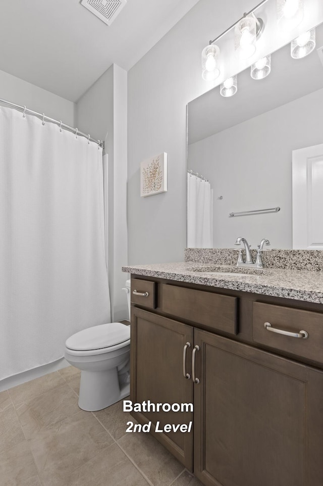 bathroom with vanity, toilet, and tile patterned floors