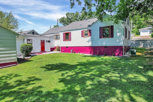 rear view of property featuring a lawn and roof with shingles