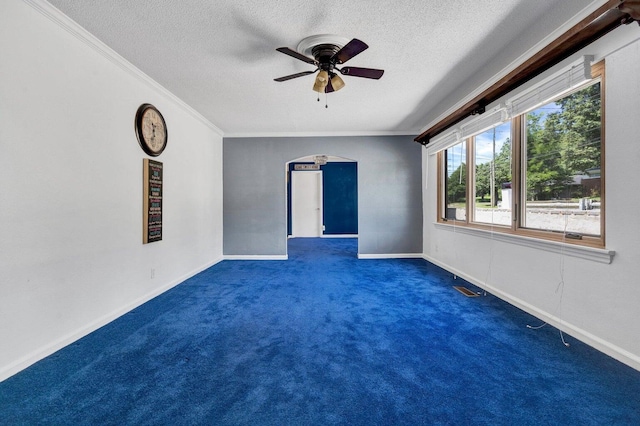 unfurnished room featuring crown molding, a ceiling fan, a textured ceiling, and dark carpet