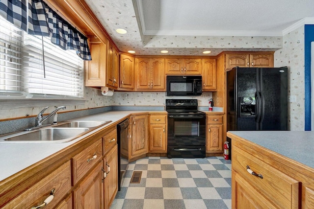 kitchen featuring ornamental molding, light floors, light countertops, a sink, and black appliances