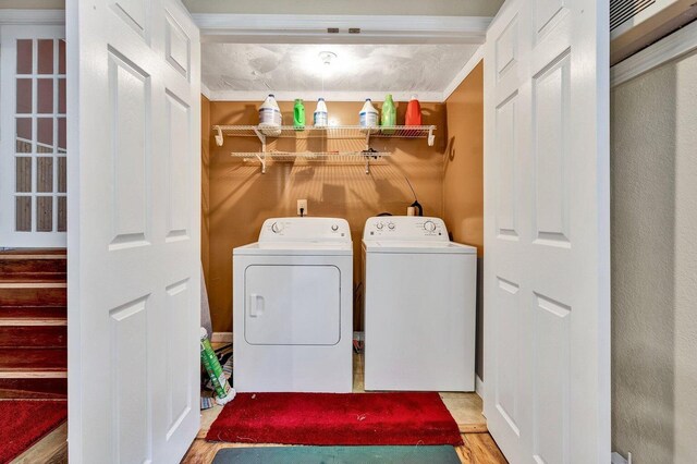 laundry area with laundry area, wood finished floors, and washer and clothes dryer