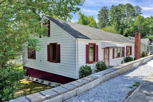 exterior space featuring a shingled roof and crawl space