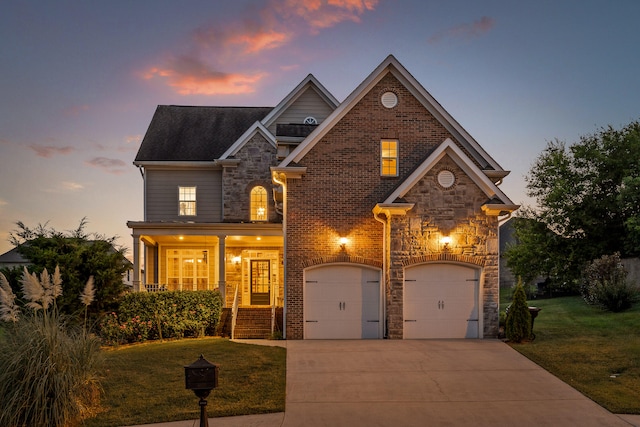 front facade featuring a garage, a yard, and covered porch