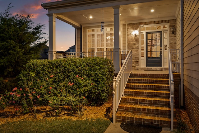 exterior entry at dusk featuring a porch