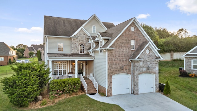 view of front of home featuring a garage, covered porch, and a front yard