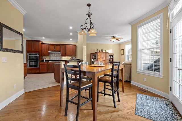 dining area featuring ceiling fan with notable chandelier, crown molding, and light hardwood / wood-style flooring